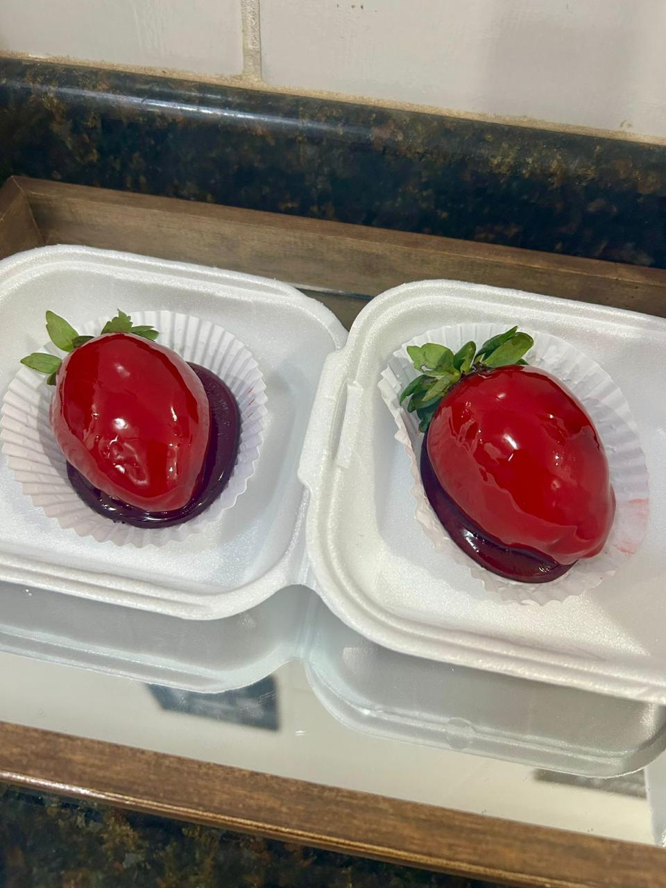 Morangos gourmet cobertos com chocolate espelhado vermelho, feitos artesanalmente pela Delicê Confeitaria